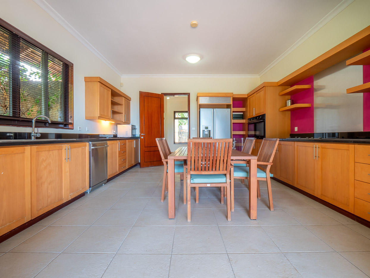 Modern kitchen and stylish dining area in a Tamarina villa by Ohana Heritage Group